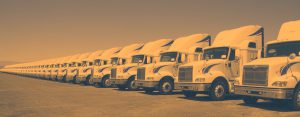 A fleet of semi trucks parked in a row.